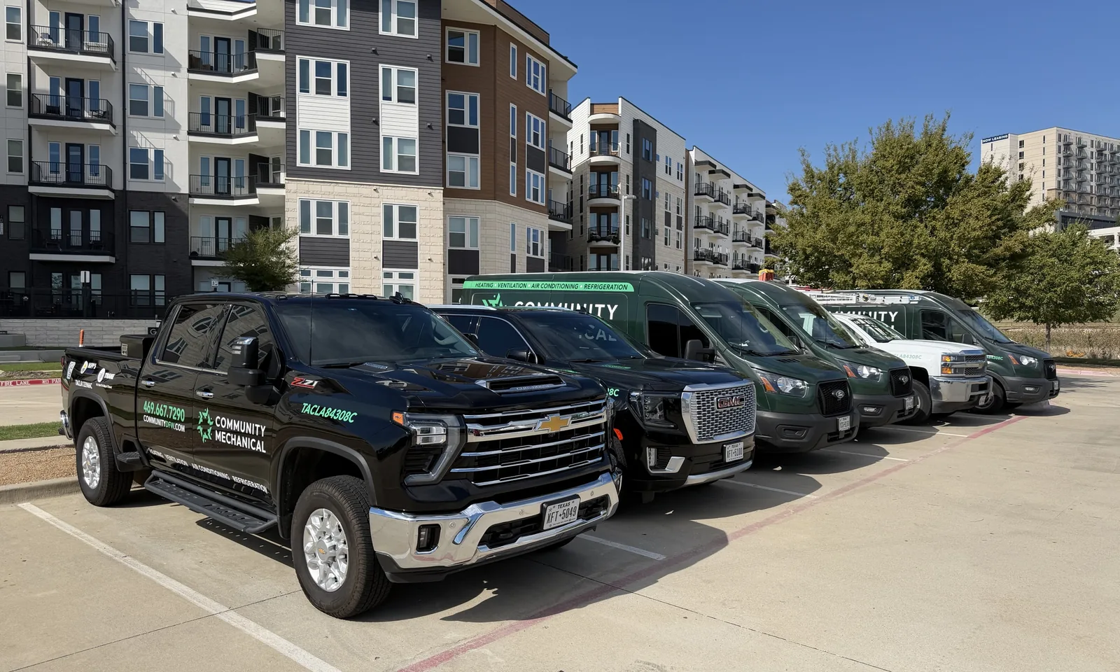 Community Mechanical trucks and vans lined up in front of an apartment community